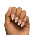 White French Tips press-on nails with sheer nude base and white French tips in almond or round almond shape, short length, matte finish, shown on hand